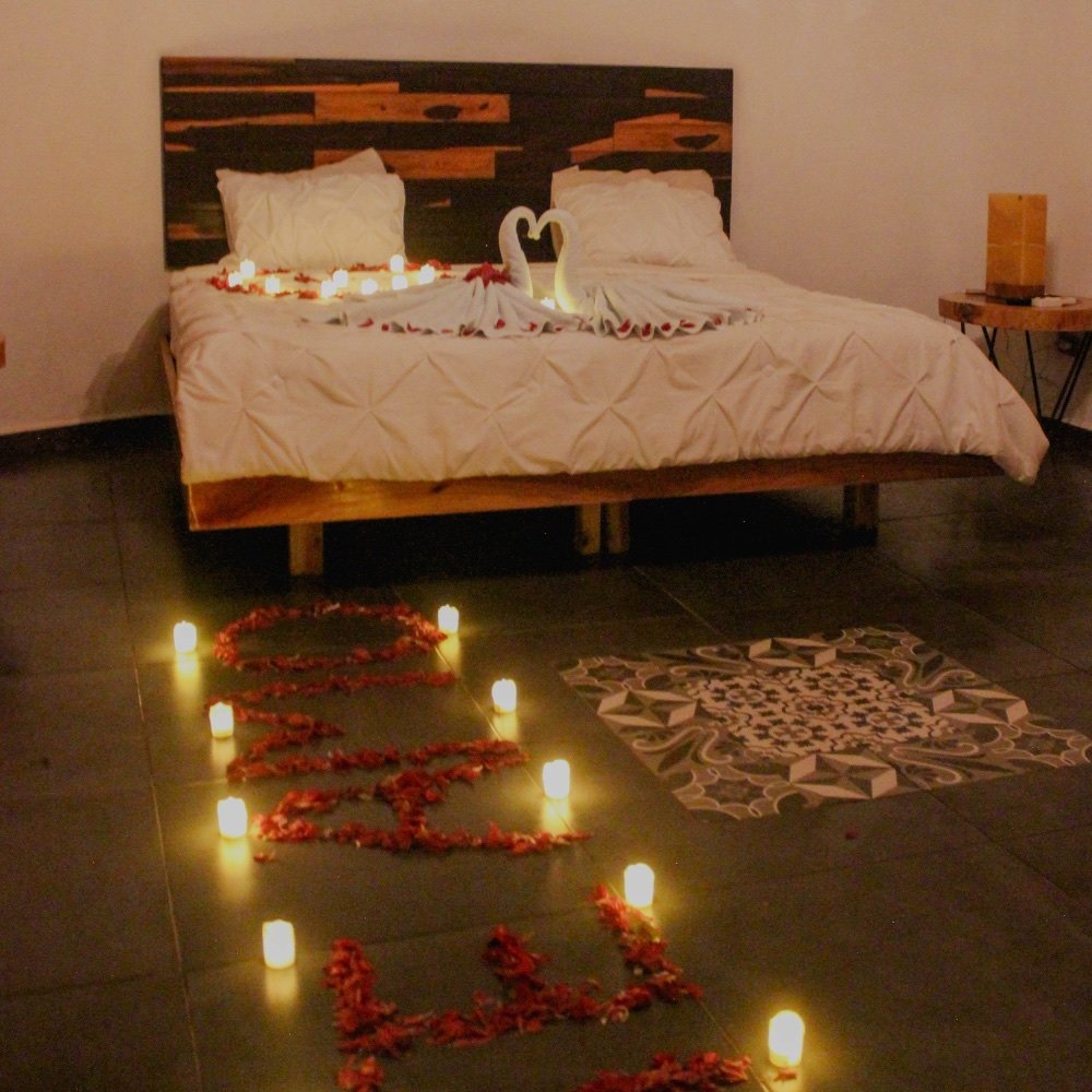 Habitación decorada con pétalos y velas para una noche romántica
