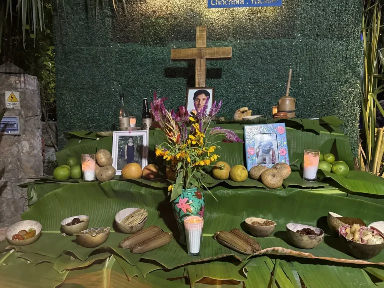 Altar con ofrendas y fotografías bajo el letrero de Cenote San Ignacio