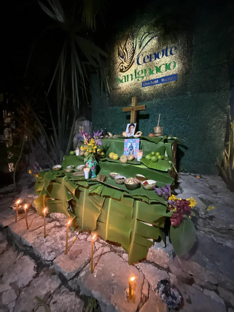 Altar tradicional iluminado con velas en Cenote San Ignacio
