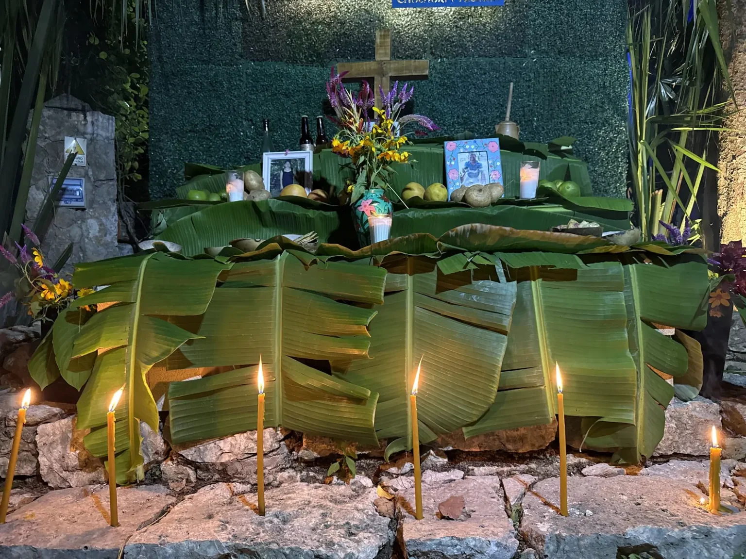 Altar tradicional yucateco con velas, flores y ofrendas en Cenote San Ignacio
