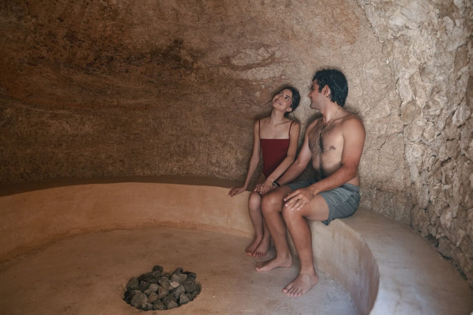 Pareja dentro del temazcal con piedras volcánicas